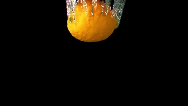 Super zpomalený citron padá pod vodu se vzduchovými bublinami. Natočeno na vysokorychlostní kameře rychlostí 1000 snímků za sekundu. — Stock video
