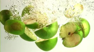 Su altında hava kabarcıkları olan süper yavaş hareket eden taze elma parçaları. 1000 fps hızla yüksek hızlı bir kamerayla çekildi..