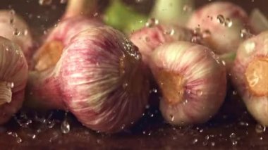 Süper yavaş çekimde su damlacıkları sarımsağın üzerine düşer. 1000 fps hızla yüksek hızlı bir kamerayla çekildi..