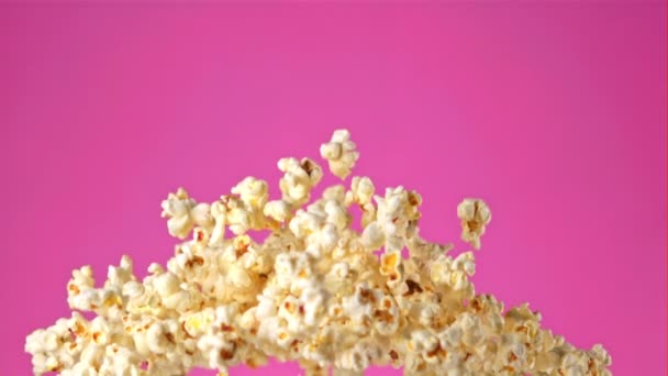Super zpomalený popcorn létá na růžovém pozadí.Natočeno na vysokorychlostní kameře při 1000 snímcích za sekundu. — Stock video
