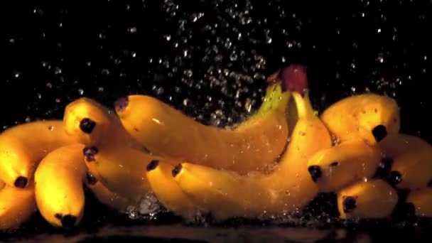 Gotas de água de movimento super lento caem sobre bananas. Filmado em uma câmera de alta velocidade a 1000 fps. — Vídeo de Stock