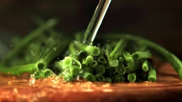 El chorro de agua de cámara súper lenta vierte sobre la cebolla verde. Filmado en una cámara de alta velocidad a 1000 fps. — Vídeos de Stock