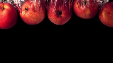 Süper yavaş çekim sulu elmalar hava kabarcıklarıyla suya düşer. 1000 fps hızla yüksek hızlı kamera ile çekilir..