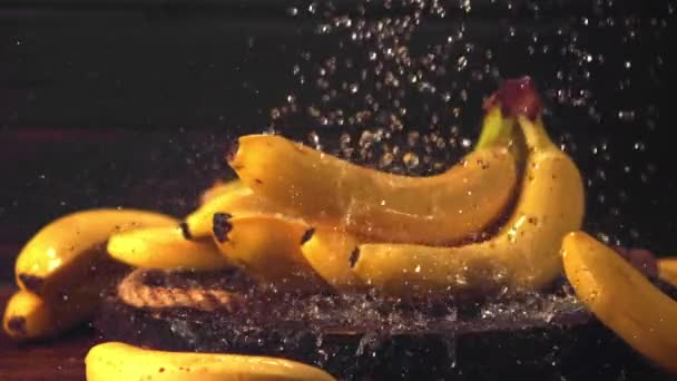 El agua en cámara súper lenta cae sobre los plátanos. Filmado en una cámara de alta velocidad a 1000 fps. — Vídeos de Stock