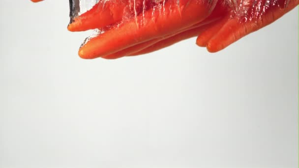 Супер медленное движение морковь падает под воду с пузырьками воздуха. Снято на высокоскоростную камеру со скоростью 1000 кадров в секунду. — стоковое видео