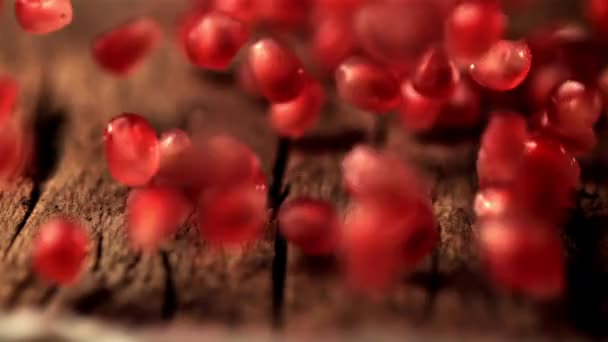 Superlangzame beweging van granaatappelkorrels rollen over de houten tafel. Gefilmd op een hoge snelheidscamera met 1000 fps. — Stockvideo