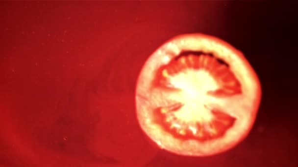 Super slow motion runt en bit tomat faller i tomatsaften. Inspelning på en höghastighetskamera vid 1000 fps. — Stockvideo