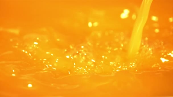 Super powolny ruch strumienia soku pomarańczowego wylewa się z rozpryskami. Nagrywane z prędkością 1000 fps. — Wideo stockowe