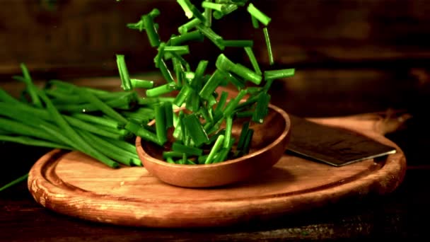 Placa de movimiento súper lento con cebolla verde picada cae sobre la mesa. Filmado a 1000 fps. — Vídeos de Stock