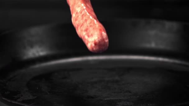 Super slow motion rauwe worsten vallen op de pan. Gefilmd op een hoge snelheidscamera met 1000 fps. — Stockvideo