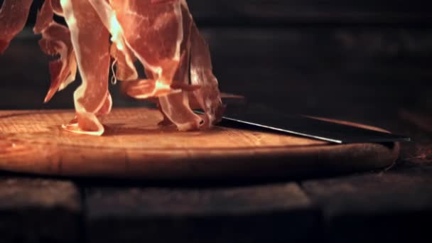 Super slow motion gesneden in dunne stukjes ham valt op een snijplank met een mes. Gefilmd met 1000 fps. — Stockvideo
