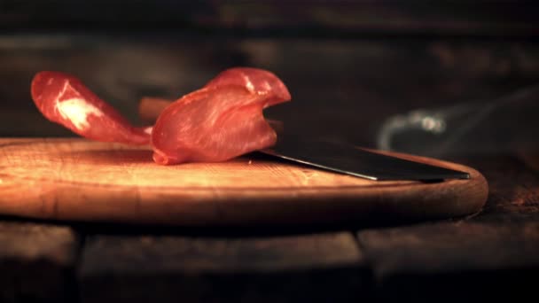 Pedaços perfumados de carne seca de movimento super lento caem na tábua de corte. Filmado em uma câmera de alta velocidade a 1000 fps. — Vídeo de Stock