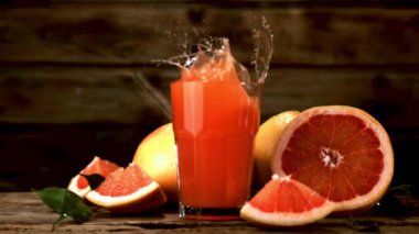 Greyfurtlu bir bardakta süper yavaş çekimde bir parça greyfurt üzerine sprey dökülüyor. 1000 fps hızla yüksek hızlı bir kamerayla çekildi..
