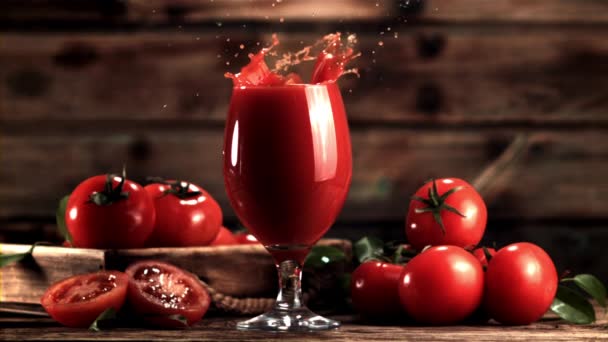 Super zpomalení ve sklenici s rajčatovou šťávou padá kus rajčete. Natočeno na vysokorychlostní kameře rychlostí 1000 snímků za sekundu. — Stock video