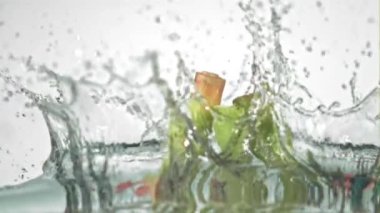 Süper yavaş çekimde sarımsak başları beyaz arka planda suyun altına düşer. 1000 fps hızla yüksek hızlı bir kamerayla çekildi.. 
