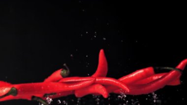 Kırmızı biberin su damlalarıyla yükselen süper yavaş hareketi. 1000 fps hızla yüksek hızlı bir kamerayla çekildi..
