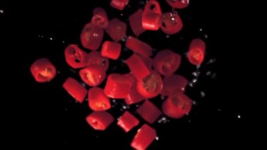 Su damlacıklarıyla kırmızı biber doğranmış süper yavaş çekim. 1000 fps hızla yüksek hızlı bir kamerayla çekildi..