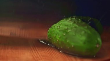 Bıçakla ikiye ayrılmış süper yavaş çekimde taze salatalık kesimi. 1000 fps hızla yüksek hızlı bir kamerayla çekildi..