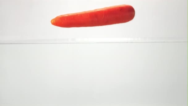 Super slow motion one carrot falls under the water with splashes and air bubbles. Filmed on a high-speed camera at 1000 fps. — Stok video