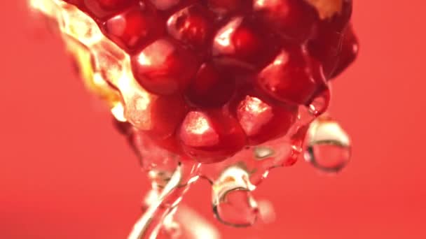 Super-Zeitlupe mit einem Stück Granatapfel leitet Wasser ab. Gefilmt mit einer Hochgeschwindigkeitskamera bei 1000 fps. — Stockvideo