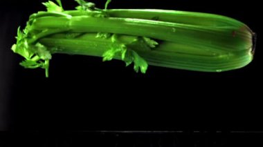 The super slow motion of the celery falls with splashes in the water. Filmed on a high-speed camera at 1000 fps.