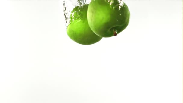 Σούπερ αργή κίνηση ολόκληρα πράσινα μήλα πέφτουν κάτω από το νερό με φυσαλίδες αέρα. Τραβηγμένο σε κάμερα υψηλής ταχύτητας στα 1000 fps. — Αρχείο Βίντεο