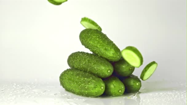 Super slow motion pieces of cucumber fall on a bunch of cucumbers on the table. Filmed on a high-speed camera at 1000 fps. — Stock Video