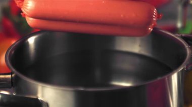 Süper yavaş çekimde sosisler su püskürtücü ile tavaya düşer. 1000 fps hızla yüksek hızlı bir kamerayla çekildi..