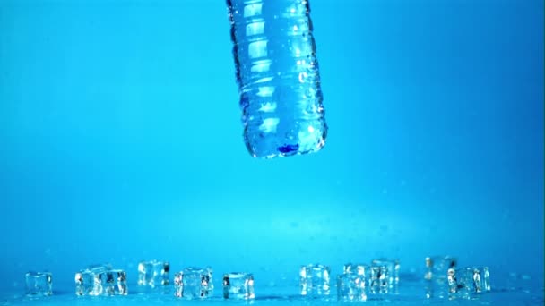 Garrafa de água super lenta com água cai sobre a mesa com gelo. Filmado a 1000 fps. — Vídeo de Stock