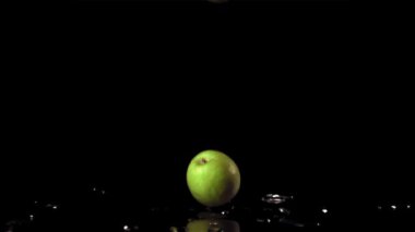 Süper yavaş çekim yeşil elmalar masaya düşer. 1000 fps hızla yüksek hızlı bir kamerayla çekildi..