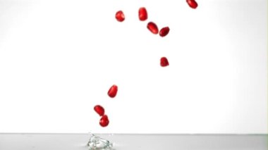 Süper yavaş çekimde nar taneleri suya su sıçratarak düşer. 1000 fps hızla yüksek hızlı bir kamerayla çekildi..