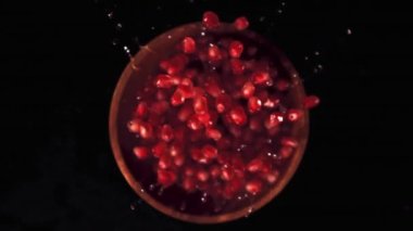 Tahta bir tabakta olgun nar taneciklerinin süper yavaş çekimi. 1000 fps hızla yüksek hızlı bir kamerayla çekildi..