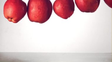 Süper yavaş çekimde kırmızı elmalar suya su sıçratarak düşer. 1000 fps hızla yüksek hızlı bir kamerayla çekildi..