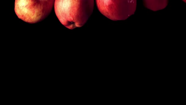 Las manzanas rojas de cámara súper lenta caen al agua con salpicaduras. Filmado en una cámara de alta velocidad a 1000 fps. — Vídeos de Stock