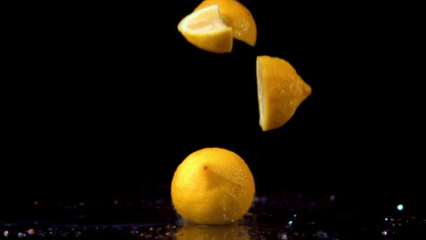 Trozos súper lentos de limón fresco caen sobre la mesa con salpicaduras de agua.Filmado en una cámara de alta velocidad a 1000 fps. — Vídeos de Stock