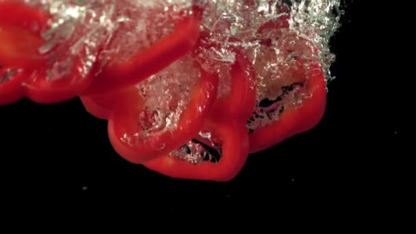 Super pomalé plátky sladkého pepře spadnou pod vodu.Natočeno na vysokorychlostní kameře při 1000 snímcích za sekundu. — Stock video