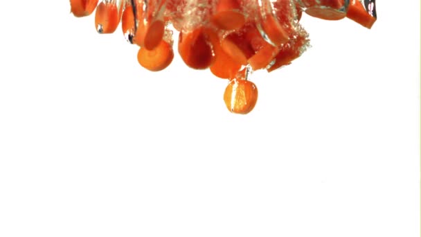 Σούπερ αργής κίνησης κομμάτια φρέσκων καρότων πέφτουν κάτω από το νερό με φυσαλίδες αέρα. Τραβηγμένο σε κάμερα υψηλής ταχύτητας στα 1000 fps. — Αρχείο Βίντεο