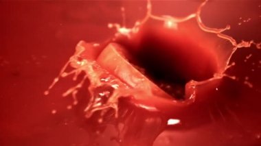 Domates suyunda süper yavaş çekim bir parça domates düşürür. 1000 fps hızla yüksek hızlı bir kamerayla çekildi..