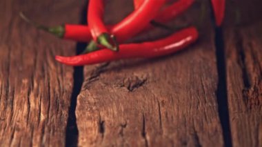 Süper yavaş çekimde kırmızı biber ahşap tahtalarda yuvarlanır. 1000 fps hızla yüksek hızlı bir kamerayla çekilir..