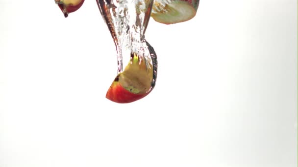 Super zpomalený film, hromada kousků jablek spadne pod vodu se vzduchovými bublinami. Natočeno na vysokorychlostní kameře rychlostí 1000 snímků za sekundu. — Stock video