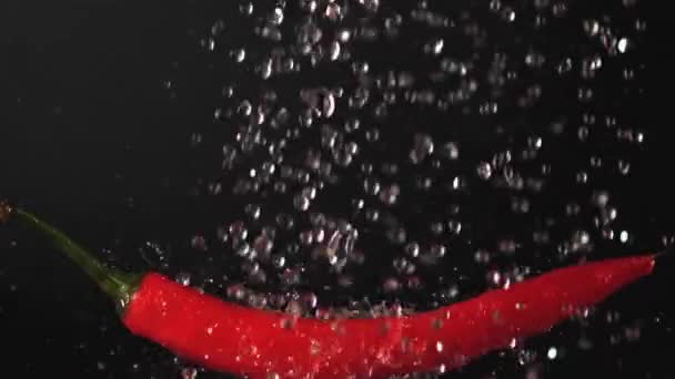 Super cámara lenta en gotas de agua de chile rojo. Filmado en una cámara de alta velocidad a 1000 fps. — Vídeo de stock