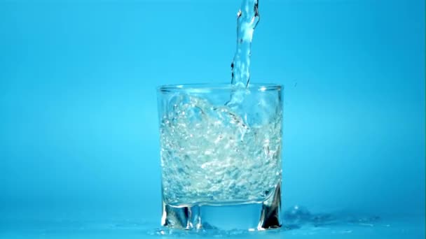 Szuper lassított felvételű tiszta víz ömlik a pohárba. 1000 fps sebességű kamerával filmezve. — Stock videók