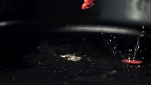 Super langzame beweging van gehakt valt op de pan met spatten olie. Gefilmd met 1000 fps. — Stockvideo