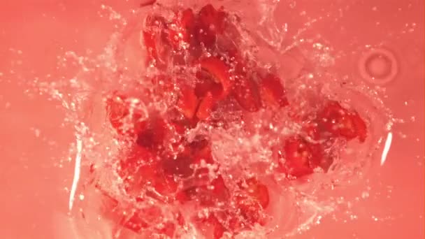 Super cámara lenta en rodajas de chile rojo cae pimienta en el agua con salpicaduras. Filmado en una cámara de alta velocidad a 1000 fps. — Vídeos de Stock