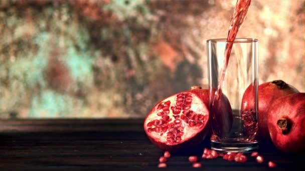 Super slow motion is a jet of pomegranate juice pouring into the glass on the table. Filmed on a high-speed camera at 1000 fps. — Stock Video