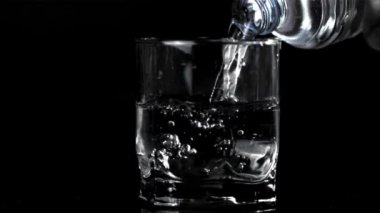 Şişeden süper yavaş çekimde bardağa su dök. 1000 fps hızla yüksek hızlı bir kamerayla çekildi..