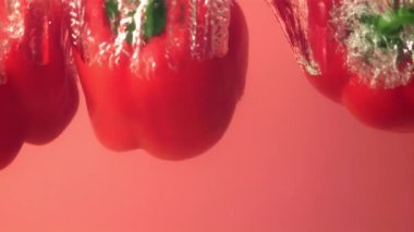 Süper yavaş çekimde kırmızı dolma biber hava kabarcıklarıyla suya düşer..