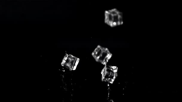 Super zpomalené kostky ledu padají na stůl s cákáním. Natočeno při 1000 snímcích za sekundu. — Stock video