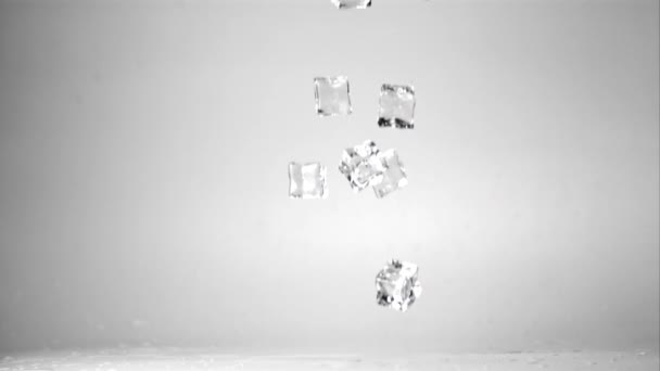 Super slow motion ijsblokjes vallen op tafel. Gefilmd op een hoge snelheidscamera met 1000 fps. — Stockvideo