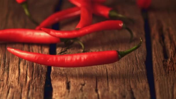 Super zpomalené červené chilli rolky na dřevěných deskách.Natočeno na vysokorychlostní kameře při 1000 snímcích za sekundu. — Stock video